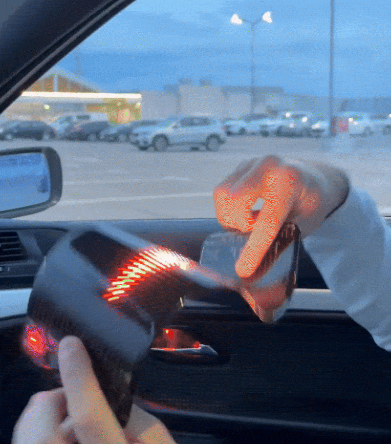Person showcasing the Gelrova Customizable Car LED Display with vibrant animations in a car.