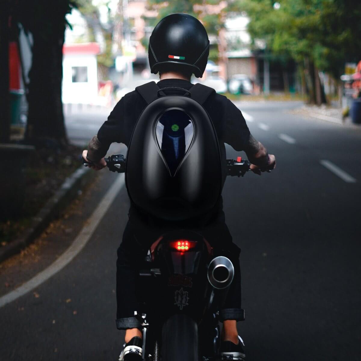 Rider using Gelrova Motorcycle LED Backpack - Sea Heart Series, showcasing innovative LED display on a motorcycle.