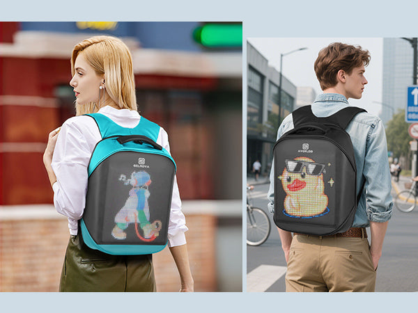 Two models, a man and a woman, wearing Gelrova City Series pixel backpacks in a city street setting. The backpacks display unique custom pixel art: a cool yellow duck with sunglasses and a futuristic blue dog.