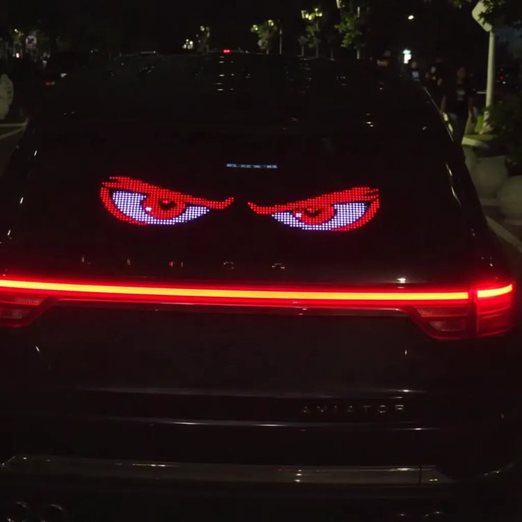Night driving view of a car's rear window illuminating the dark with the Gelrova Demon Eyes 2 Pack Car Window LED Display.
