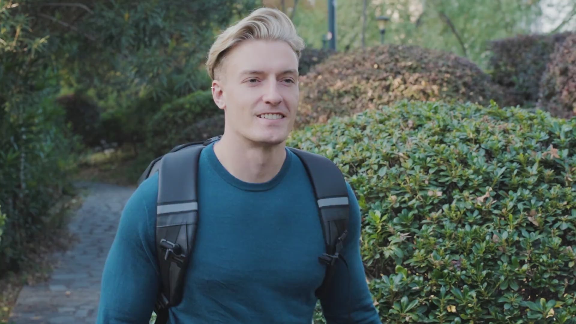 A rider wearing the Gelrova Knight Pro LED motorcycle backpack with custom eyes animation while riding through a scenic park road.